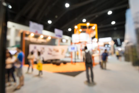 Salon professionnel avec stands d'exposition dans un hall moderne