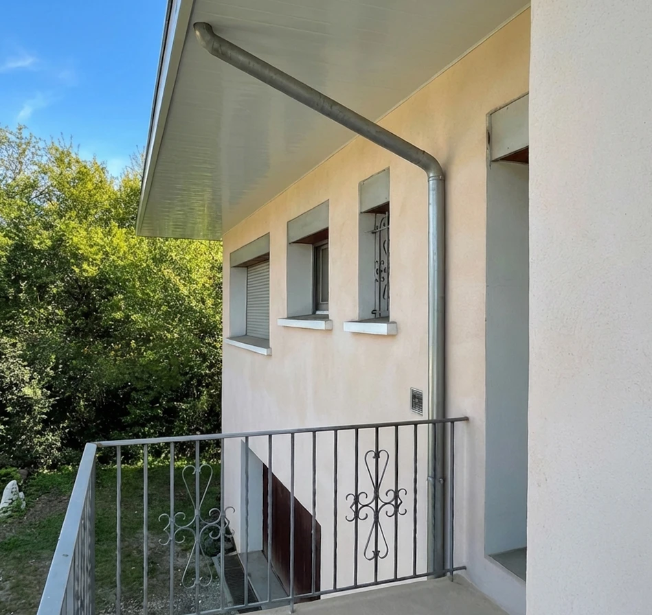 Façade extérieure d'une maison bourgeoise à enduit jaune paille, deux niveaux
